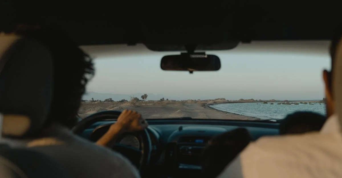 Vue intérieure de voiture lors d'une promenade pittoresque le long d'une route côtière au coucher du soleil.