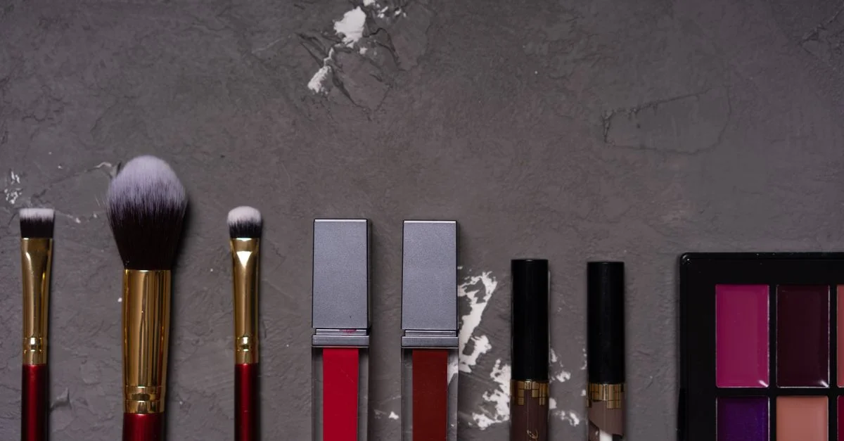 Photo de haute qualité en plan rapproché de divers pinceaux de maquillage et cosmétiques sur un fond texturé.