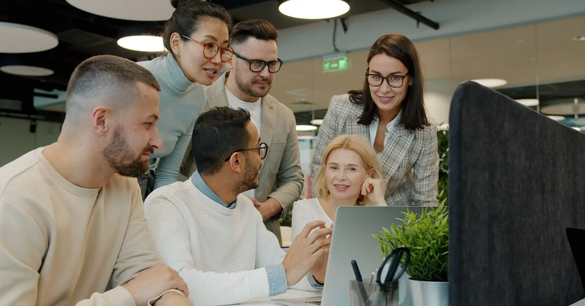 Une équipe diversifiée travaille ensemble sur un projet dans un environnement de bureau moderne, en utilisant les technologies.
